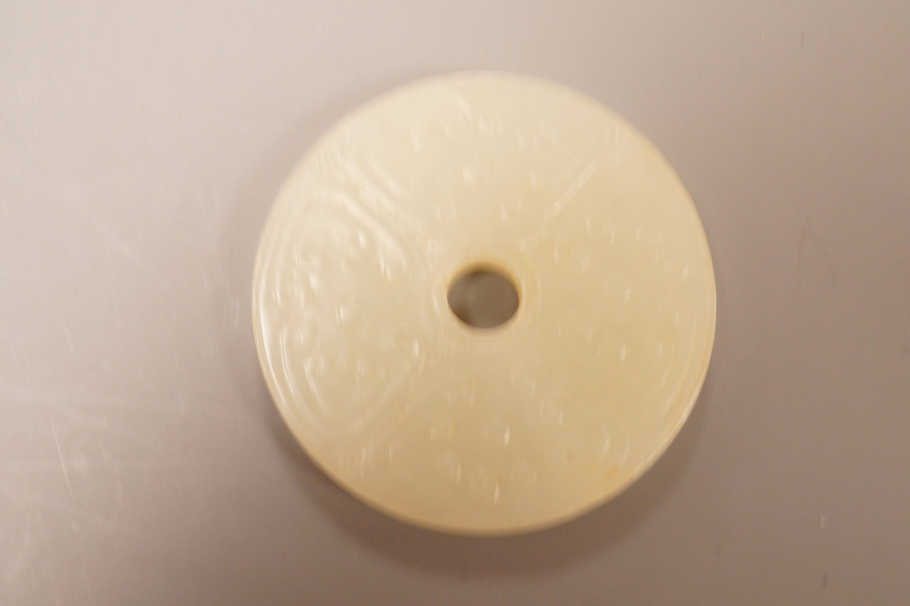 A Chinese pale celadon jade bi disc